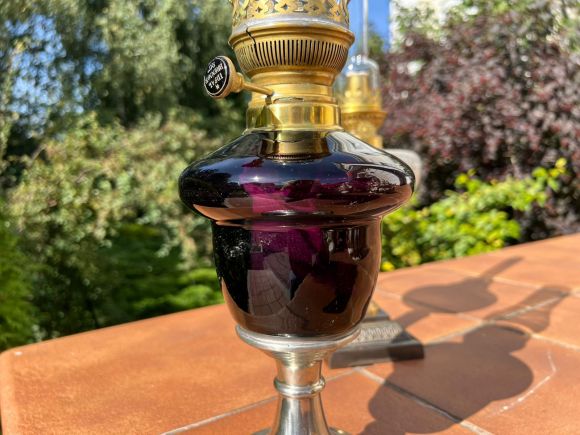 Старинная керосиновая лампа с плафоном из аметистового стекла.