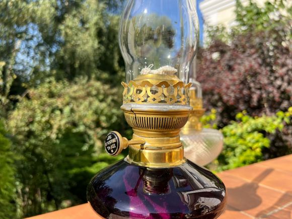 Старинная керосиновая лампа с плафоном из аметистового стекла.