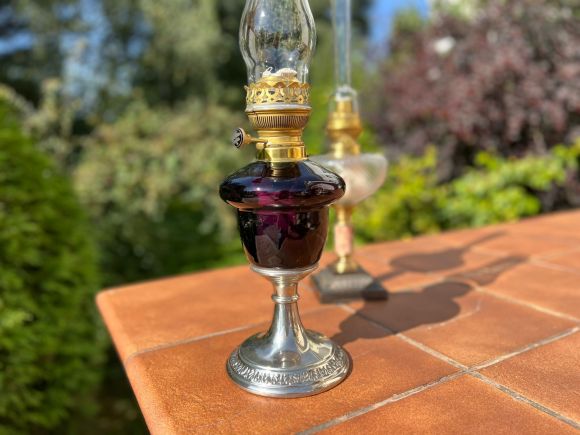 Старинная керосиновая лампа с плафоном из аметистового стекла.