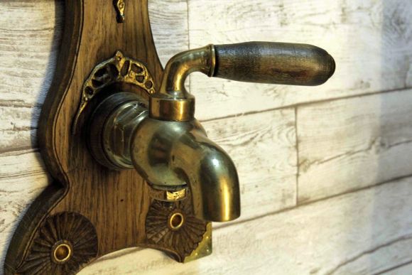 Старинный кран на дубовой резной подложке. Европа. Начало 20 века