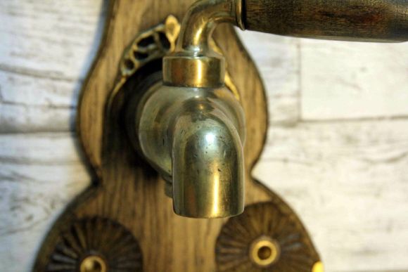Старинный кран на дубовой резной подложке. Европа. Начало 20 века