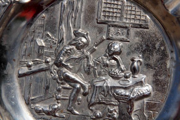 Металлическая пепельница с сюжетом о влюбленных.