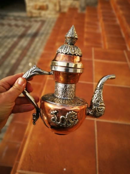 Антикварный чайник, украшенный чеканкой