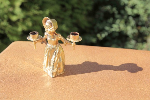 Старинный отполированный подсвечник в виде молодой девушки