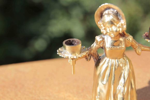Старинный отполированный подсвечник в виде молодой девушки