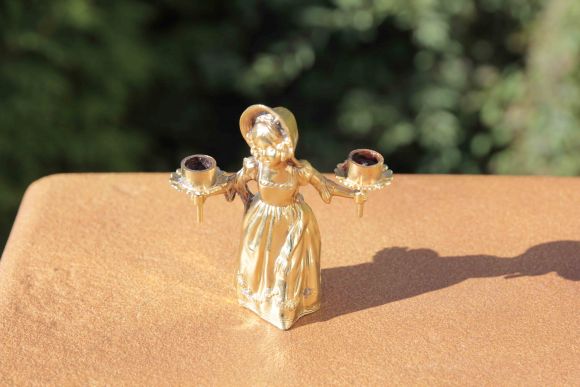 Старинный отполированный подсвечник в виде молодой девушки