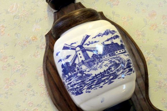 Старинная фарфоровая кофемолка на резной подставке.Европа